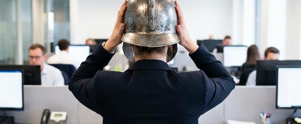 A woman at work, seen from the back, donning a gladiator helmet